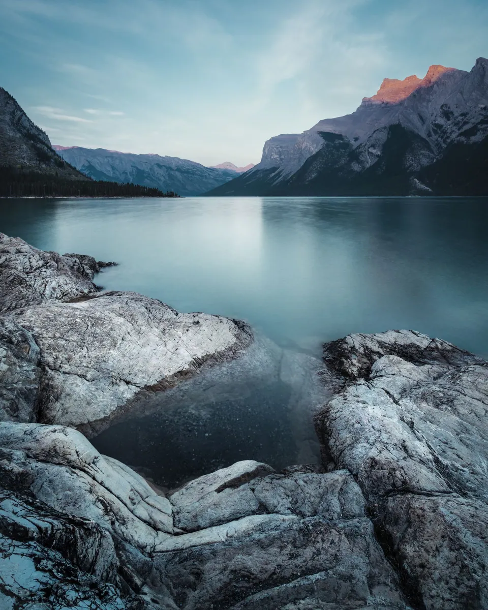 Still lake reflecting mountains in Banff, Alberta