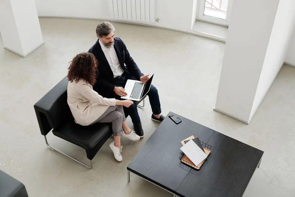 Two professionals reviewing work together in a bright office