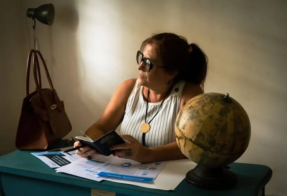 A woman reviewing travel documents beside a globe