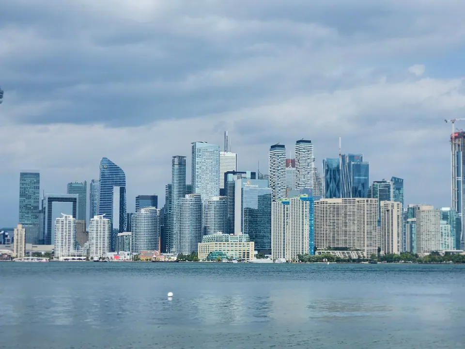 Toronto skyline across Lake Ontario beneath a cloudy sky